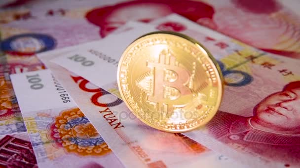 Finanzkonzept mit goldenem Bitcoin über chinesischen Yuan-Schein — Stockvideo