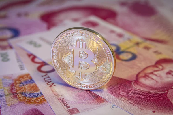 Financial concept with golden Bitcoin over chinese yuan bill — Stock Photo, Image