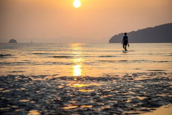 Jovem mulher andando na praia e olhando para o pôr do sol na Tailândia — Fotografia de Stock