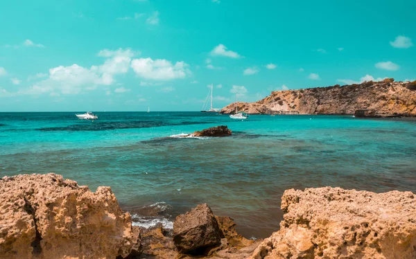 Ánimo azulado y anaranjado de Cala Tarida Playa con rocas de piedra, Isla de Ibiza. España — Foto de Stock