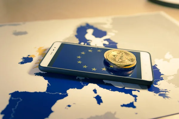 Финансовая концепция с золотыми биткойнами над смартфоном, флагом ЕС и картой . — стоковое фото