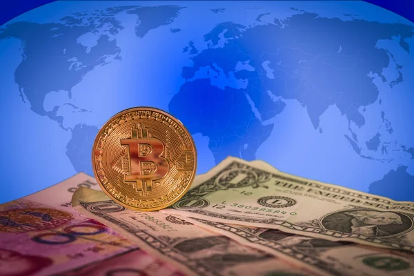 Financial growth concept with golden bitcoin above dollar and yuan bills and a world map on the background — Stock Photo, Image