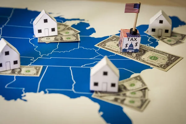 Case familiari con banconote in dollari e tassa governativa centrale su una mappa degli Stati Uniti — Foto Stock