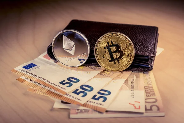 Finansiella begrepp med fysiska bitcoin och ethereum över en plånbok med euron räkningar — Stockfoto