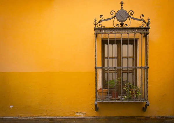 Antike mittelalterliche Fenster mit rostigen Eisenstangen und Orangewall — Stockfoto