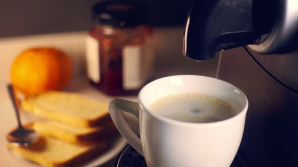 Cafetera vertiendo café expreso fresco en una taza en el desayuno . — Vídeo de stock