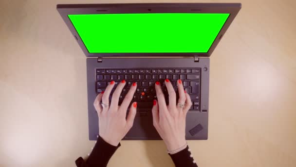 Frau arbeitet an ihrem Laptop mit grünem Bildschirm, Draufsicht — Stockvideo