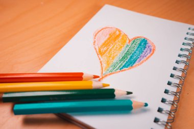 Lgtbi renginde kalp ya da gökkuşağı kalemli boş bir defter üzerinde Glbt bayrağı