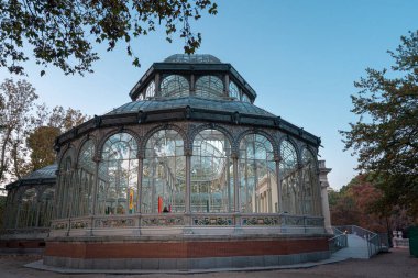 İspanya, Madrid 'deki Retiro Park' taki Kristal Saray 'ın gün batımı manzarası.
