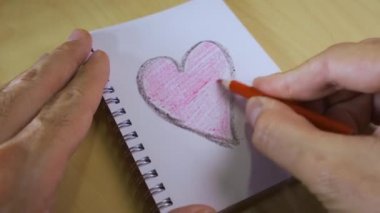 Aşk kalp bilgisayarda, kalem tahta masada.