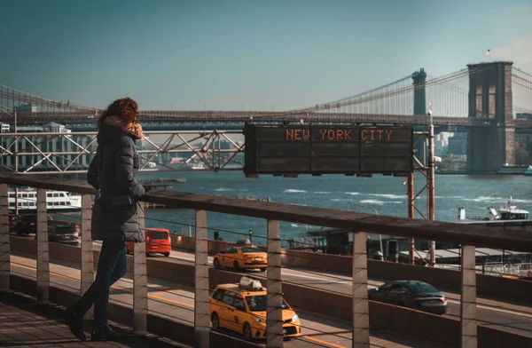 Vacker lockig brunett kvinna tittar på East River och Brookling bron från Manhattan — Stockfoto