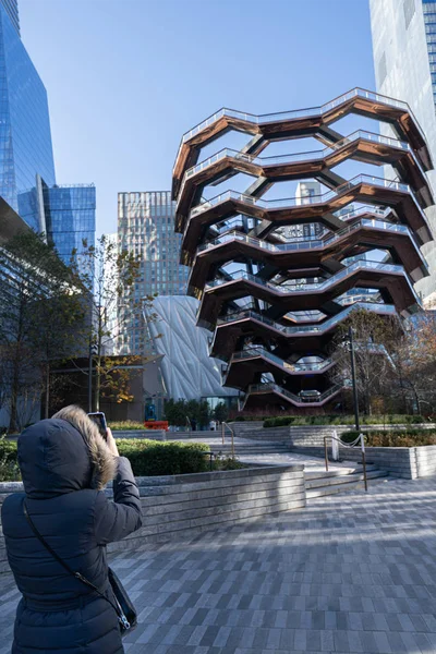 Femme avec des vêtements chauds d'hiver prenant une photo avec son smartphone dans Hudson Yards . — Photo