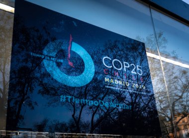 Cop25 posterinin üzerinde ağaçlar ve yapraklar yansıyor.