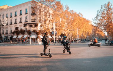 Madrid caddesinde elektrikli scooter kullanan biri..