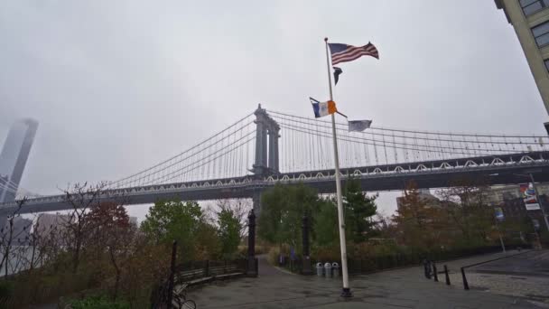 Vista en cámara lenta de la bandera americana y el puente de Manhattan desde DUMBO — Vídeos de Stock