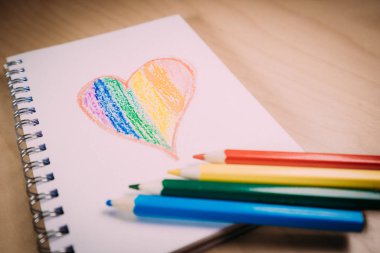 Lgtbi renginde kalp ya da gökkuşağı kalemli boş bir defter üzerinde Glbt bayrağı