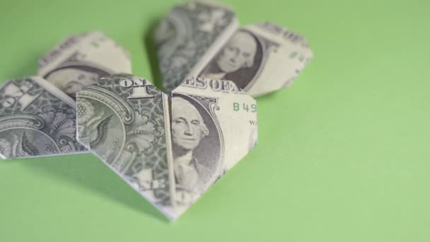 Corazones de origami de un dólar sobre un fondo verde — Vídeo de stock