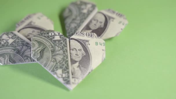 Corazones de origami de un dólar sobre un fondo verde — Vídeos de Stock