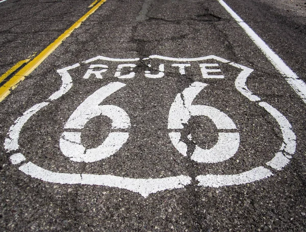 Longa estrada com um sinal da Rota 66 pintado nela — Fotografia de Stock