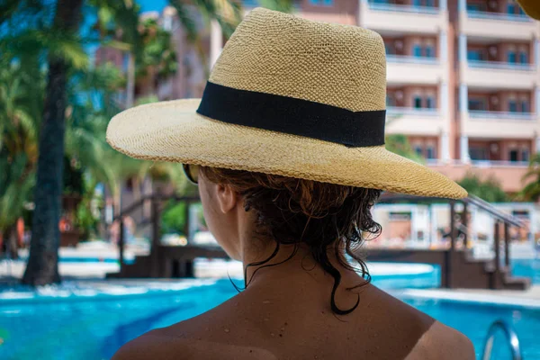 Kobieta z Kapelusz przeciwsłoneczny relaks w basenie w Spa Resort. — Zdjęcie stockowe