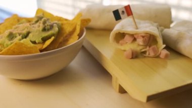 Sıcak taze burrito ve guacamole kremalı nachos yakın çekim.