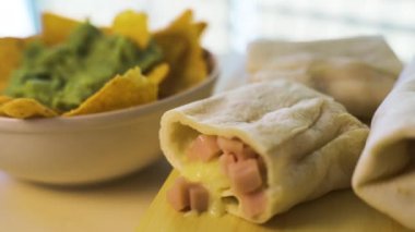 Sıcak taze burrito ve guacamole kremalı nachos yakın çekim.