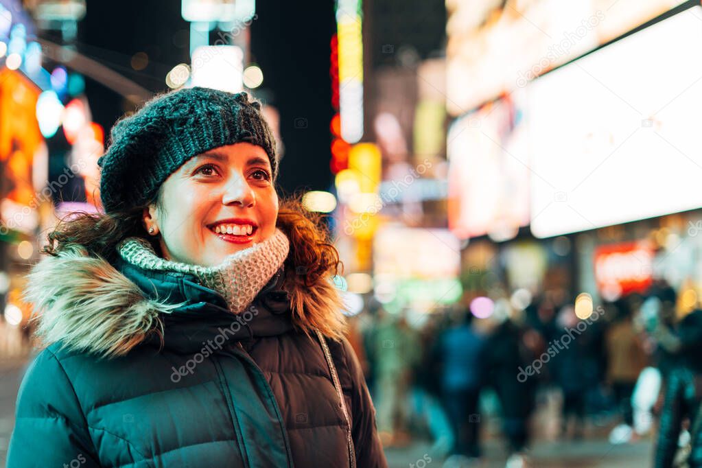 Amazed woman looking at the lights and the crowd in times square