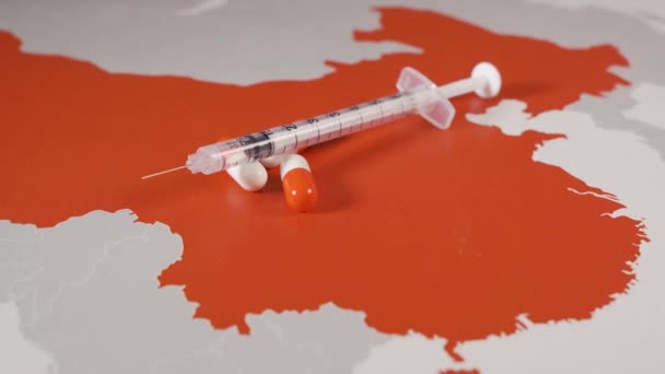 Spritze und Pillen auf einer chinesischen Landkarte. Krankheitsausbruch durch Coronavirus-Konzept — Stockvideo