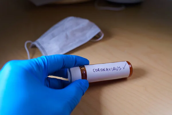 Doctor labeling a blood sample tube positive with coronavirus — Stock Photo, Image