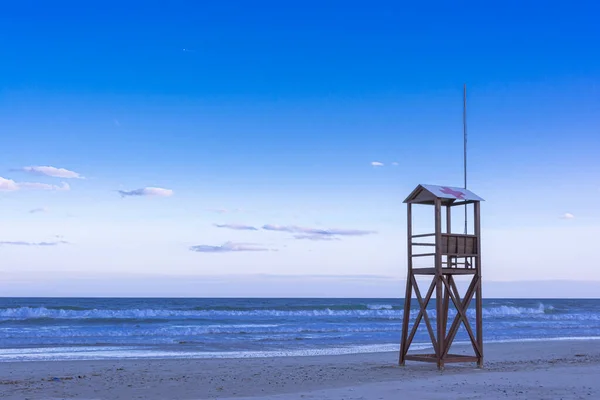 Classic Blue beach sunrise with lifeguard wooden tower — Stockfoto