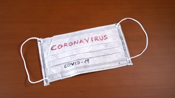 Mano con billetes en euros cubriendo una máscara facial con la palabra coronavirus — Vídeo de stock