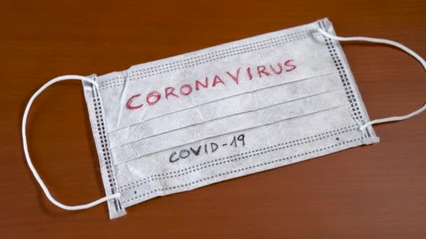 Ruka s modrými lékařskými rukavicemi, dolarovými bankovkami a obličejovou maskou se slovem coronavirus — Stock video