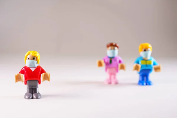 Kleine Spielzeugfigur mit Mundschutz isoliert von der Gruppe — Stockfoto