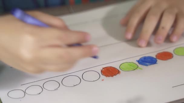 Närbild av ett barn som ritar med kritor på papper eller gör läxor hemifrån — Stockvideo