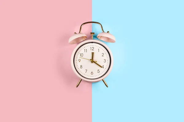 Sunet gemene clopot ceas deșteptător clasic izolat pe fundal albastru și roz pastel colorat la modă — Fotografie, imagine de stoc
