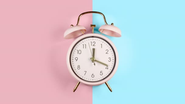 リングツインベルヴィンテージクラシック目覚まし時計ブルーとピンクのパステルカラフルなトレンディーな背景に隔離 — ストック動画