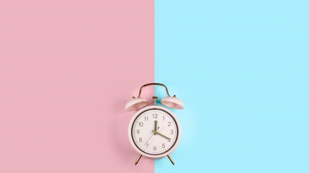 Ringing twin bell vintage classic alarm clock Isolated on blue and pink pastel colorful trendy background — Stock Video