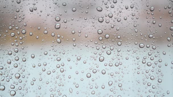 Gotas de chuva na superfície dos vidros da janela com fundo nublado — Vídeo de Stock