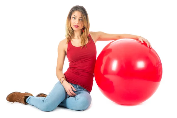 Frau sitzt mit großem roten Ballon auf dem Boden — Stockfoto