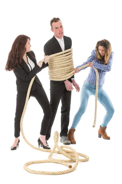 Two angry woman tying a business man with rope — Stock Photo, Image