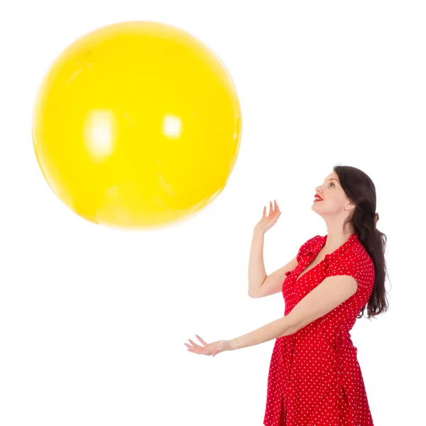 Woman catching big yellow balloon isloated on white background — Stock Photo, Image