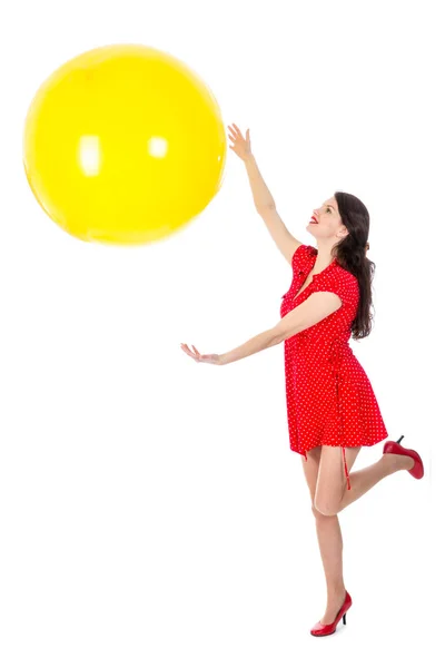 Frau fängt großen gelben Ballon auf weißem Hintergrund — Stockfoto