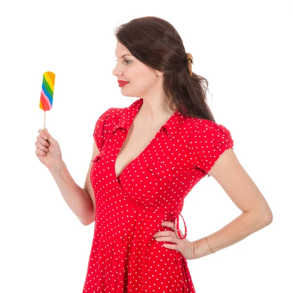 Schöne Frau im roten Kleid mit buntem Lutscher — Stockfoto