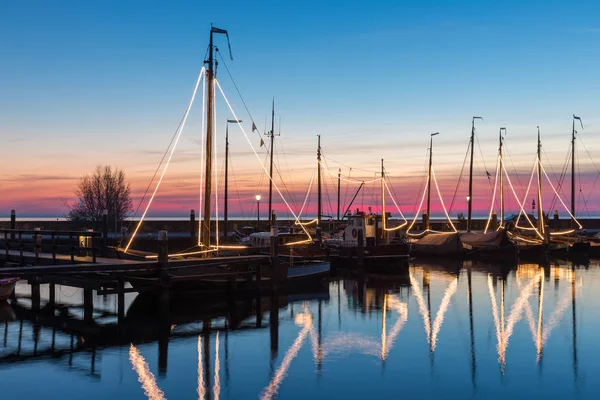 Beleuchtete traditionelle hölzerne Fischerboote in der Nacht im holländischen Hafen — Stockfoto