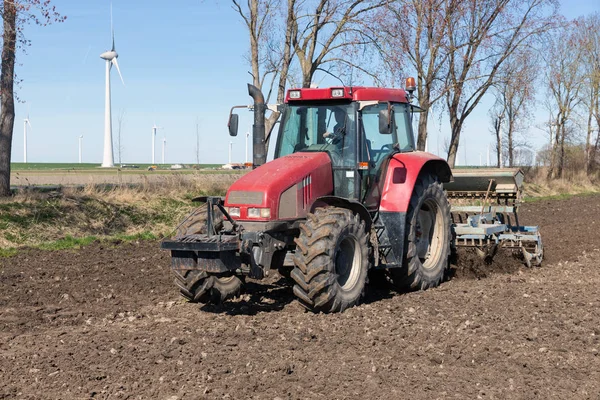 Arado tractor en el campo holandés desnudo a principios de primavera — Foto de Stock