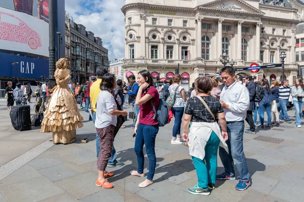 Living statue and unknown people at Piccadilly Circus in London, — Stock Photo, Image