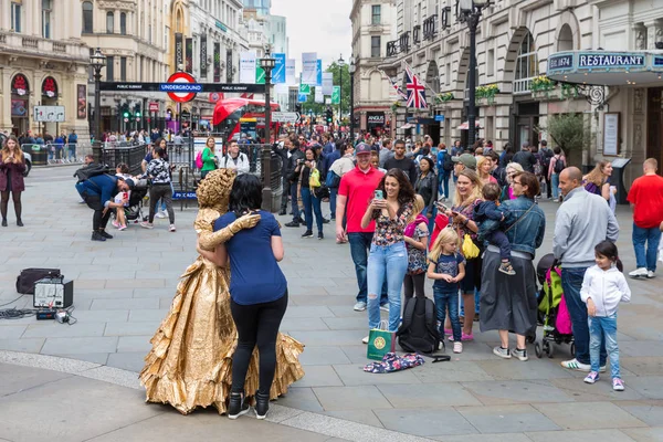 Onbekende mensen maken van foto's van levend standbeeld op Piccadilly Circ — Stockfoto