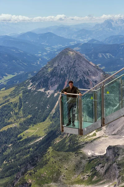 Jonge man staande bij weergave platform Oostenrijkse Dachstein bergen — Stockfoto