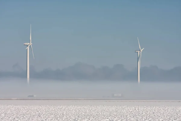 Dutch winter landscape with highway, ground fog and wind turbines — Stock Photo, Image