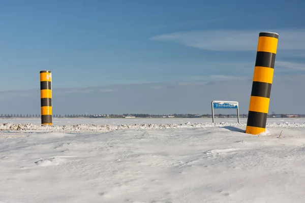 Karlı tarım arazileri ve renkli yol işaretleri ile Hollandalı kış manzarası — Stok fotoğraf